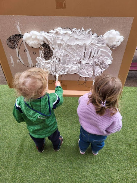 Two young children taking part in messy play in an early years setting