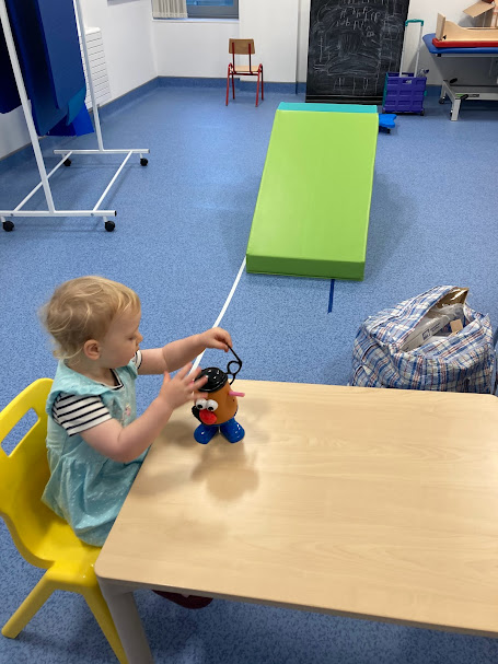 Young child playing at a small table during a play-based occupational therapy assessment