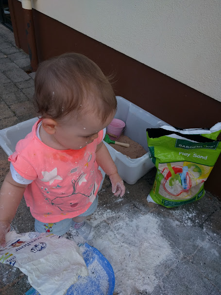 Young child exploring sand during sensory play